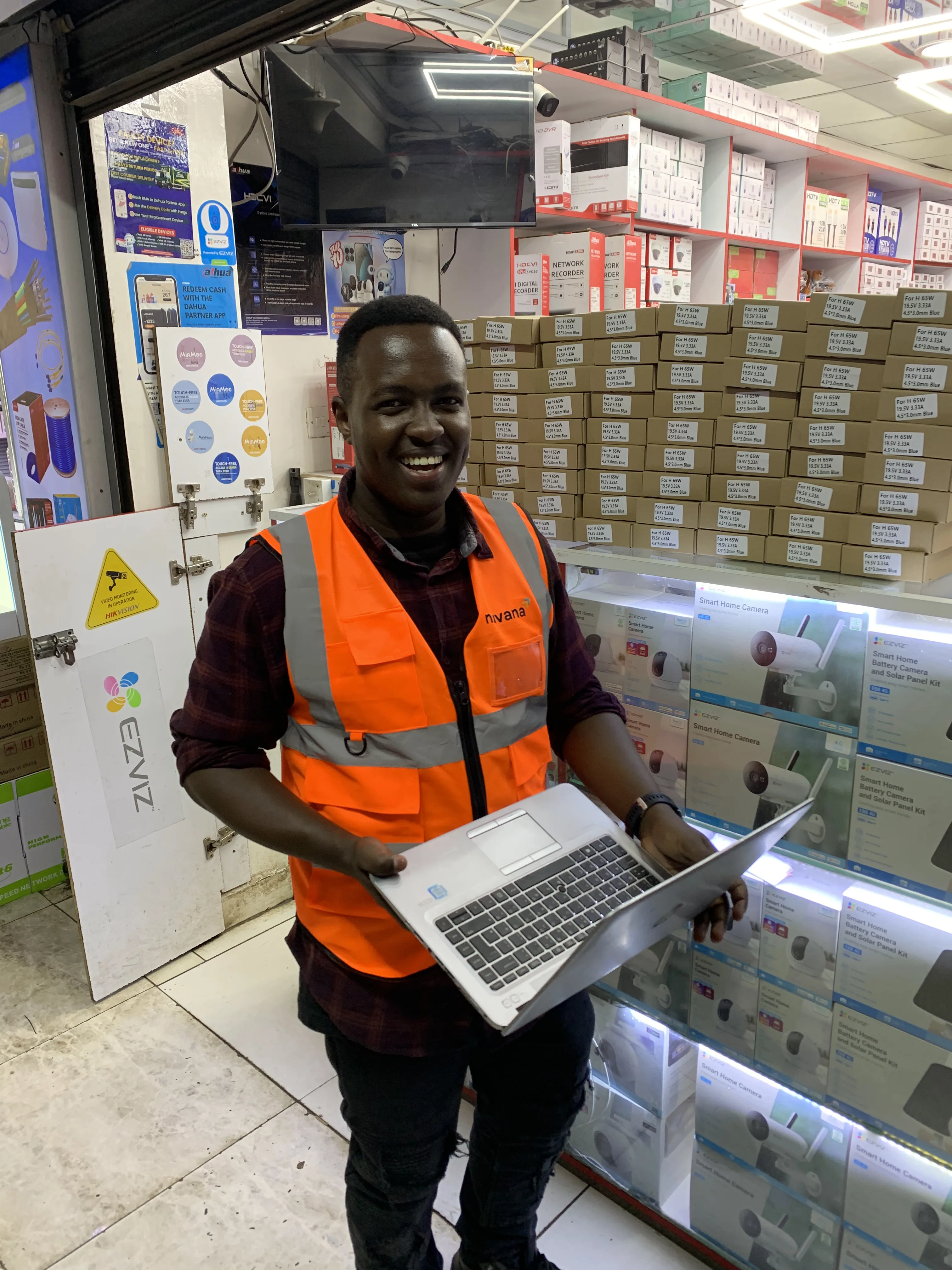 Wahome Maina working with a laptop inside a Kenyan retail business
